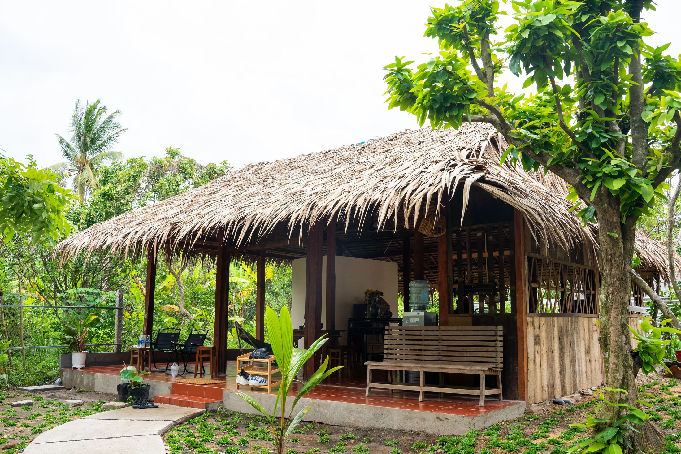 Thatched pavilion surrounded by the Mango Home garden