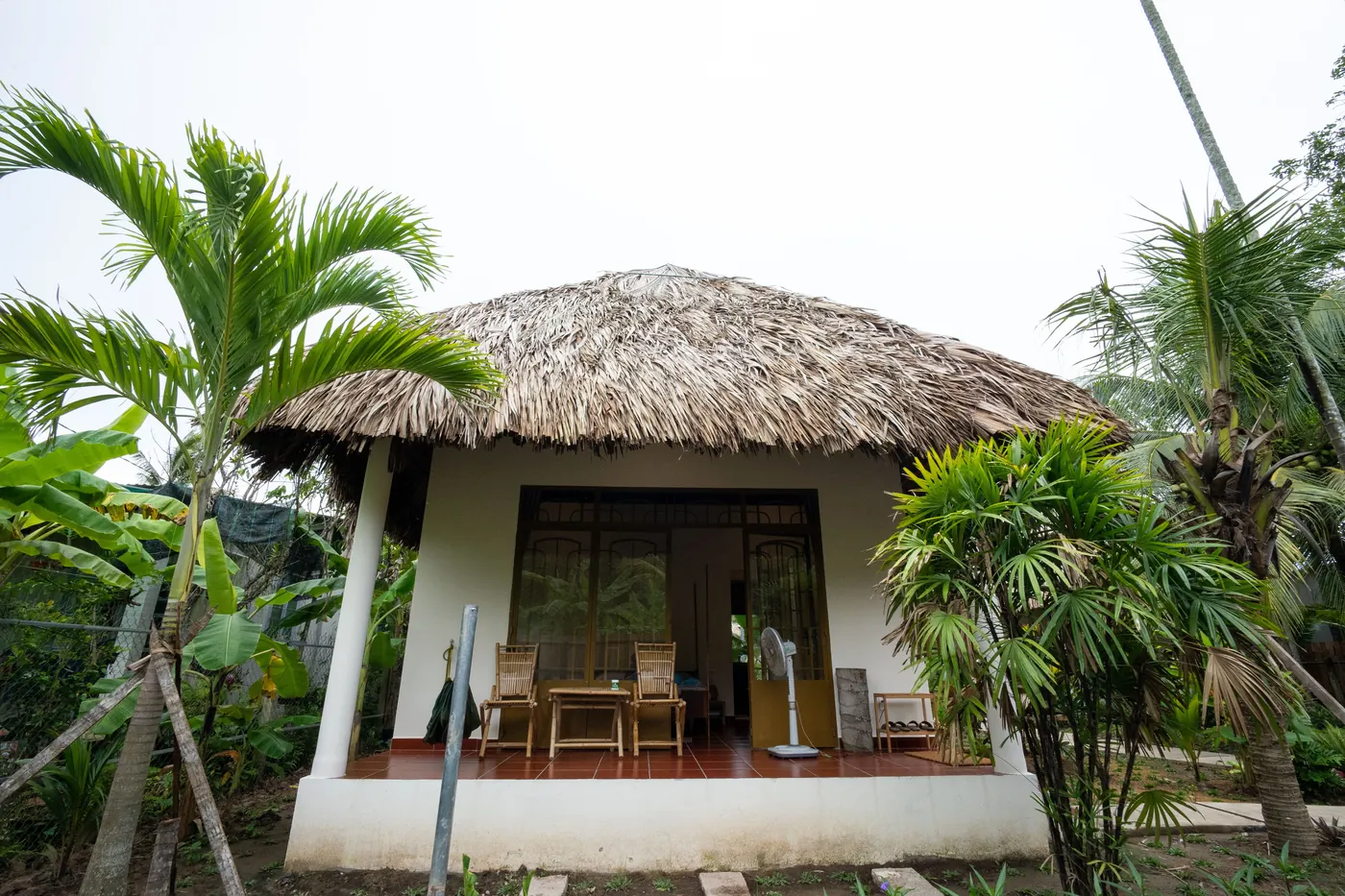 Coconut Bliss thatched bungalow surrounded by tropical plants